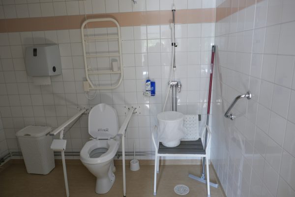 個室の中にあるバスルーム。トイレに座るための手すりや座ったままシャワーを浴びるための椅子など